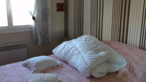 Ein Schlafzimmer mit Bett, Kissen und einem Fenster.