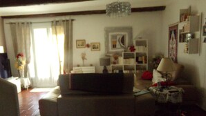 Ein Wohnzimmer mit einer Couch, einem weißen Beistelltisch, einer Lampe und einem Bücherregal.
