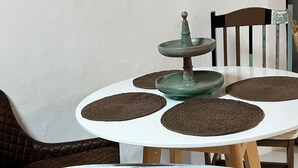 A round dining table with a white top and a green center. - Charming Little Home Terrace with wonderful ocean and mountain views. Fast Wi-Fi (Los Realejos)