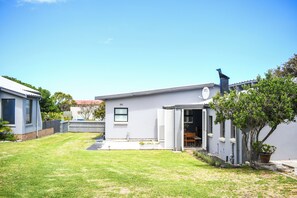 A modern house with a well-maintained lawn, a garage, and a small garden area.
