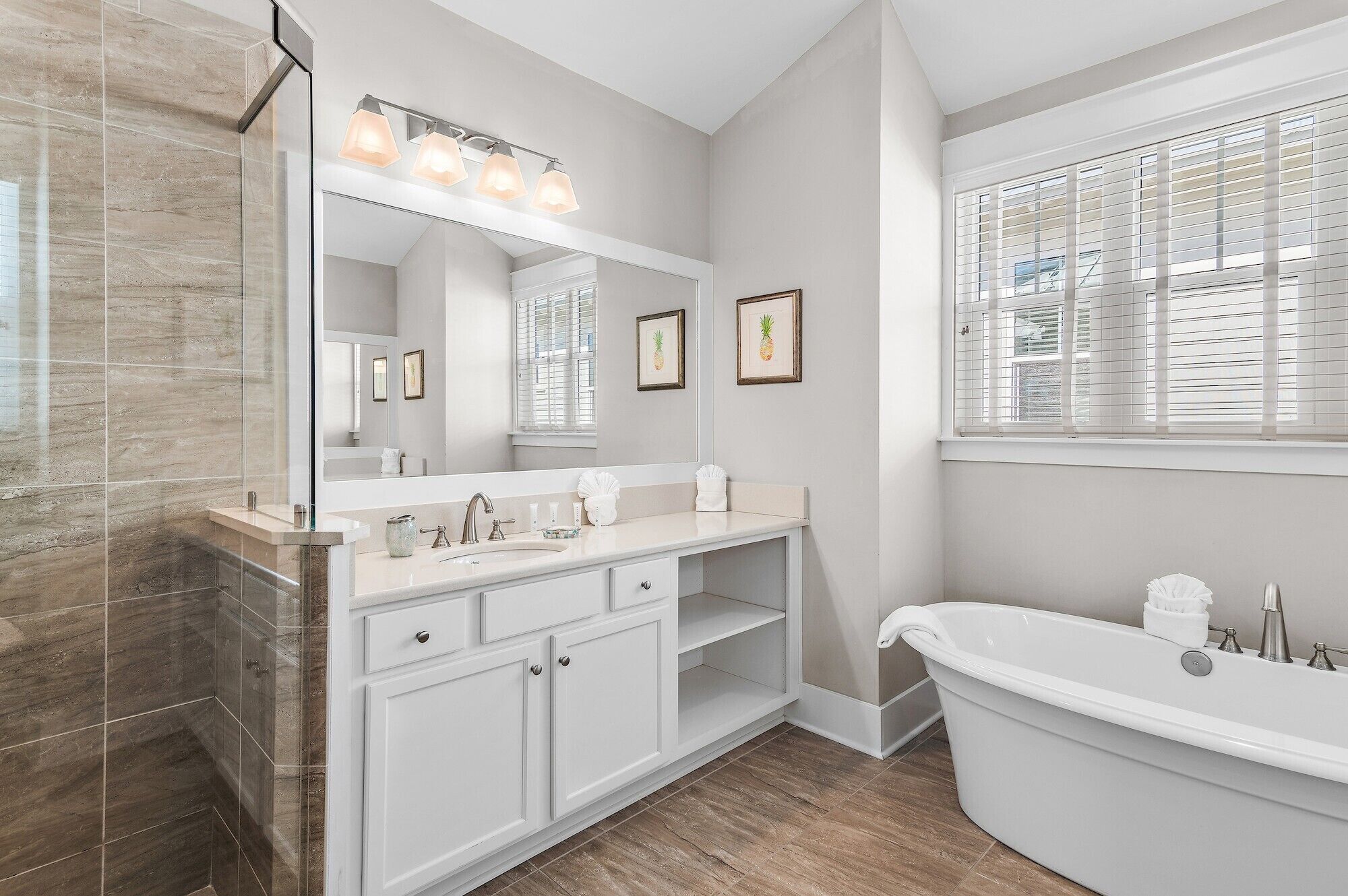 A modern bathroom with a glass shower enclosure, a vanity with a sink and mirror, and a freestanding bathtub.