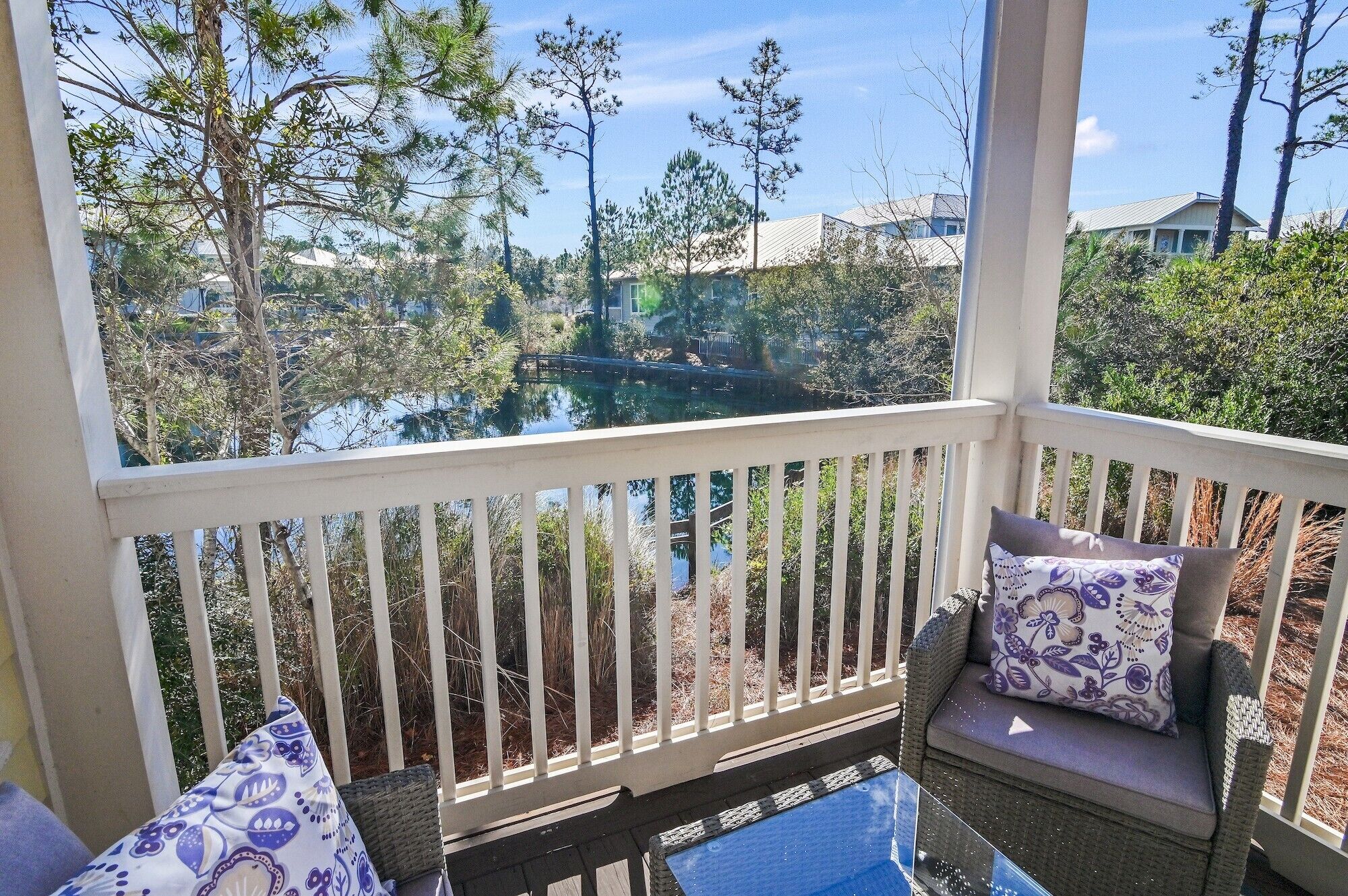 A covered outdoor seating area with a view of a lake and surrounding trees.