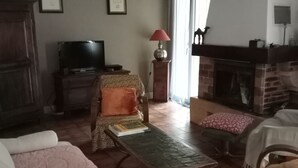 A cozy living room with a fireplace, a television, and comfortable seating. - Quiet house with garden Montignac Lascaux (Montignac-Lascaux)