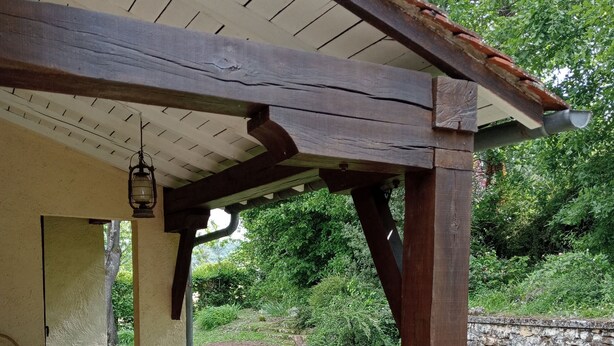 A covered patio area with a stone floor and a table. - Quiet house with garden Montignac Lascaux (Montignac-Lascaux)