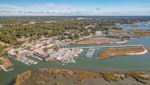 An aerial view of a coastal town with a marina, waterfront buildings, and surrounding natural landscape. - Seashell Retreat 3/2 By Beach Star (Murrells Inlet)