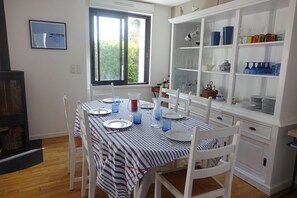 Enjoy meals in this dining area with a table for four, a cabinet for storage, and a window offering a view of the surrounding greenery.