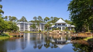 Un hotel con un grande lago, un gazebo e un edificio con una cupola caratteristica.