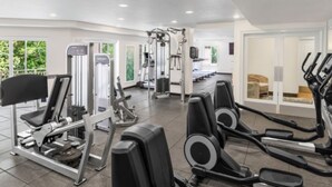Una palestra con diverse attrezzature per l'allenamento, tra cui tapis roulant e macchinari per pesi.
