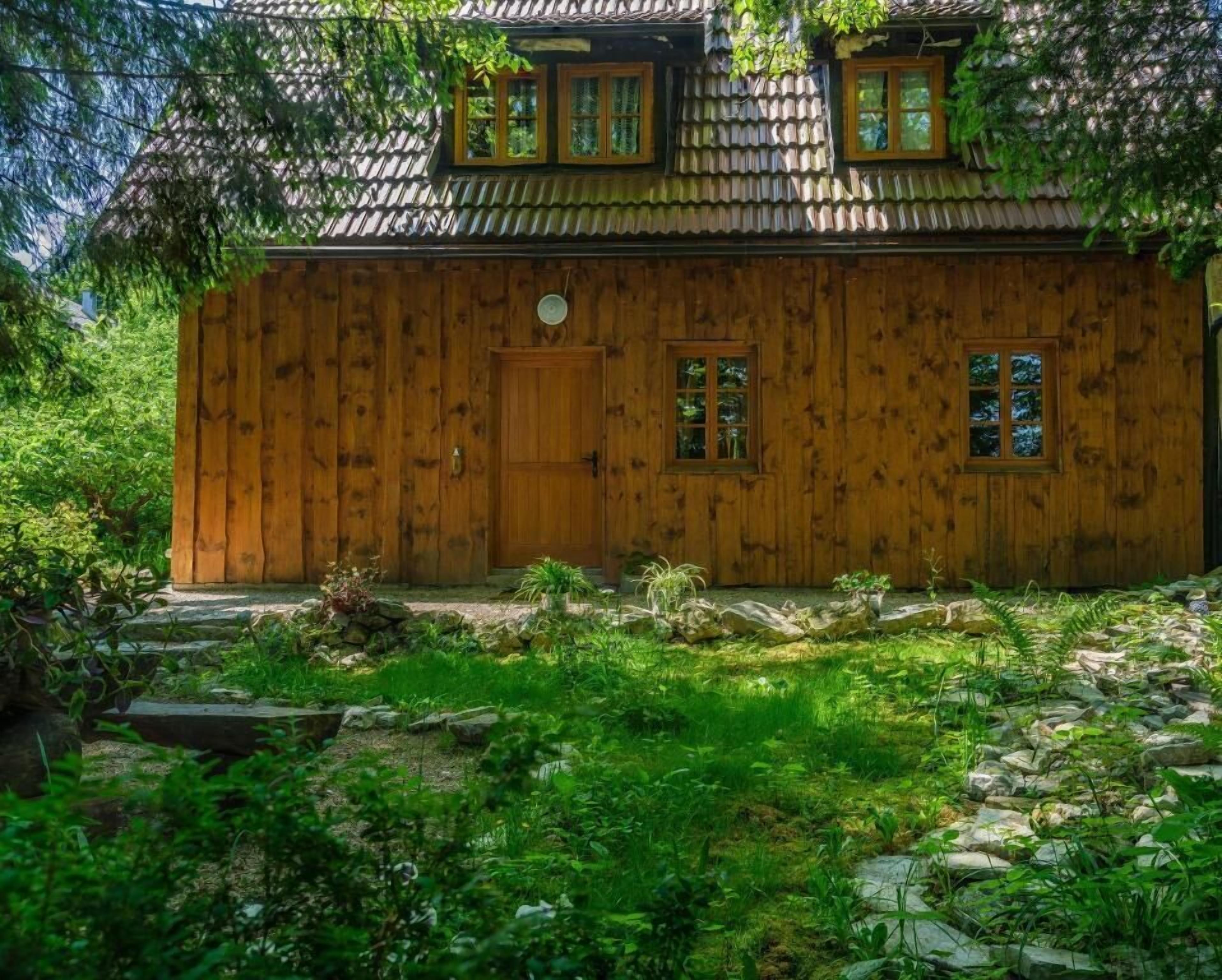 Una casa in legno con tetto in tegole, una porta in legno e due finestre.