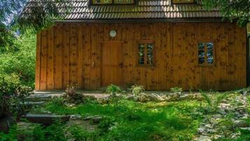 Una casa in legno con tetto in tegole, una porta in legno e due finestre.