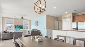 Una sala de estar moderna con comedor, cocina y vista al mar.