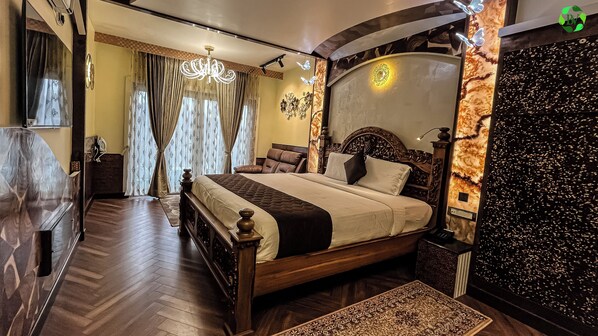 Un dormitorio espacioso con una cama grande, una araña y un muro decorativo.