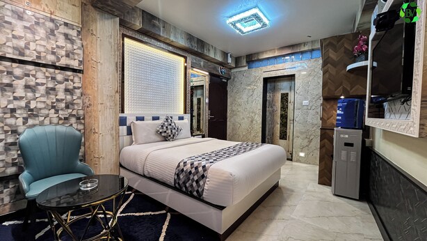 Une chambre d’hôtel moderne équipée d’un lit, d’une chaise, d’une table, d’un miroir et d’une armoire.