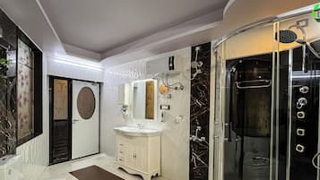 Un baño con tocador, espejo, lavabo y ducha.