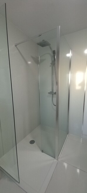 Chuveiro, toalhas de banho, sabonete, papel higiênico