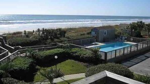 Propiedad residencial con piscina, vista a la playa y una casita.