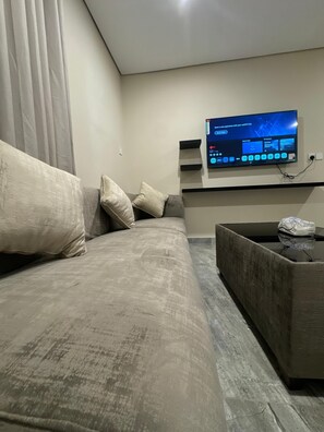 Superior appartement, 1 kingsize bed | Woonkamer | Een 100-inch smart-tv met satellietzenders