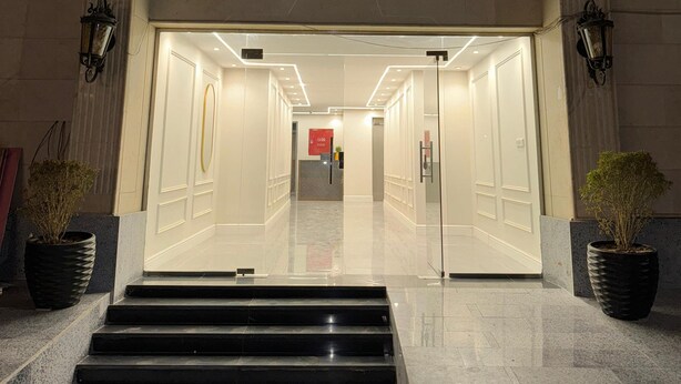 L'entrée d'un hôtel, avec un grand escalier menant à un espace d'accueil.