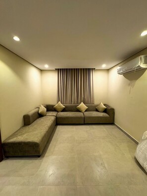 Relax in a spacious living room with a sectional sofa, chaise lounge, and long couch, perfect for unwinding.