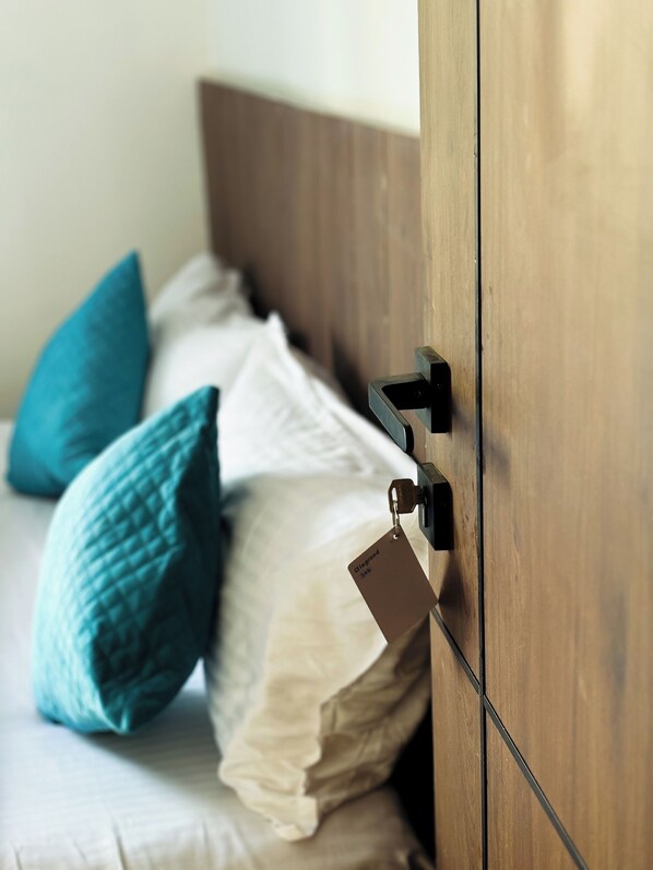 A wooden wardrobe with a metal handle and a tag attached.
