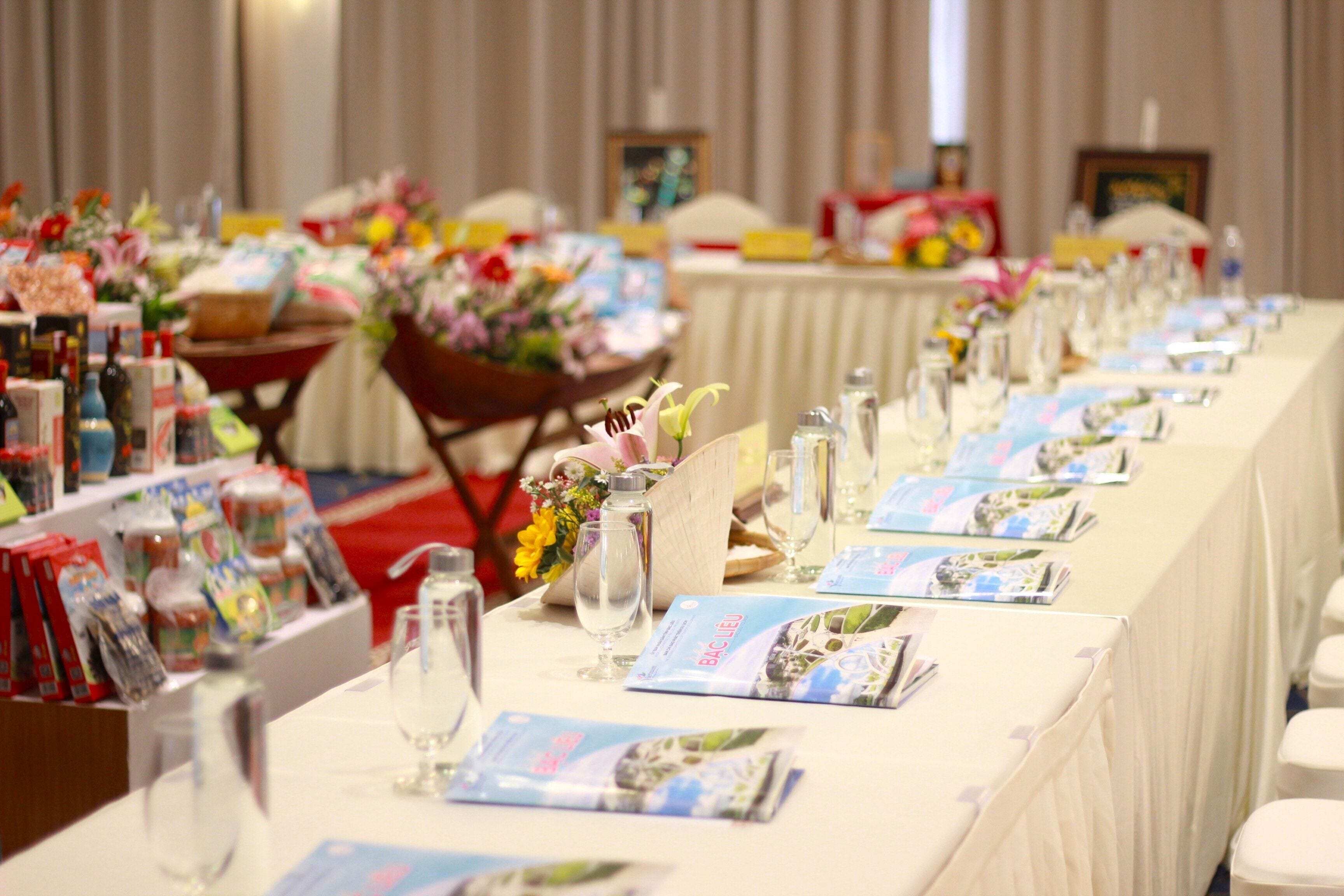 Una mesa de banquete dispuesta con cristalería, menús y centros de mesa florales.