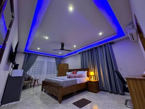 Ein modernes Schlafzimmer mit Bett, Nachttisch, Lampe und Deckenventilator.