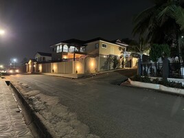 Uma casa de dois andares com varanda e portão fechado.