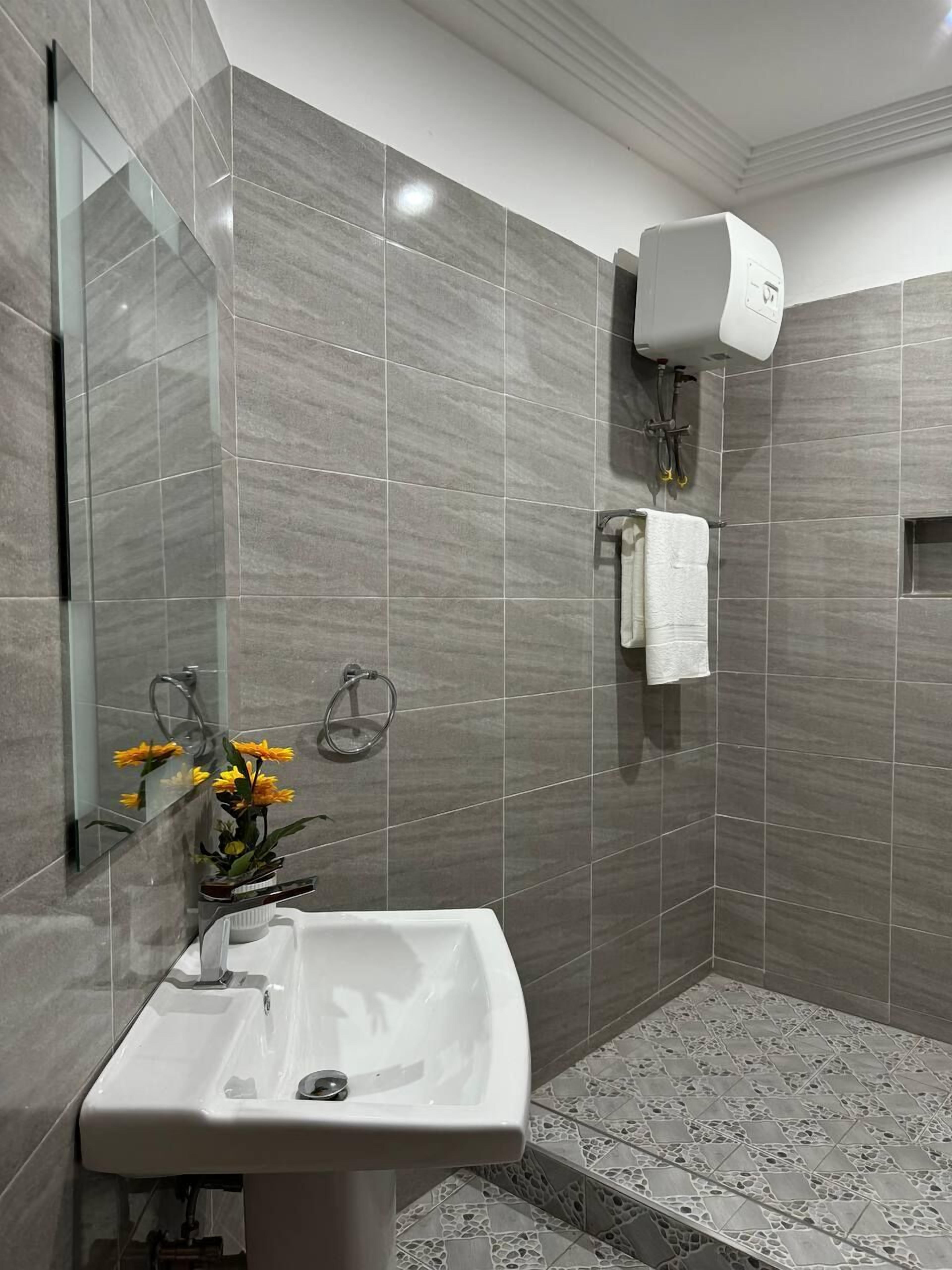 A modern bathroom with a sink, mirror, and shower.