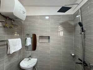 Ein modernes Badezimmer mit Dusche, Waschbecken und Handtuchhalter.