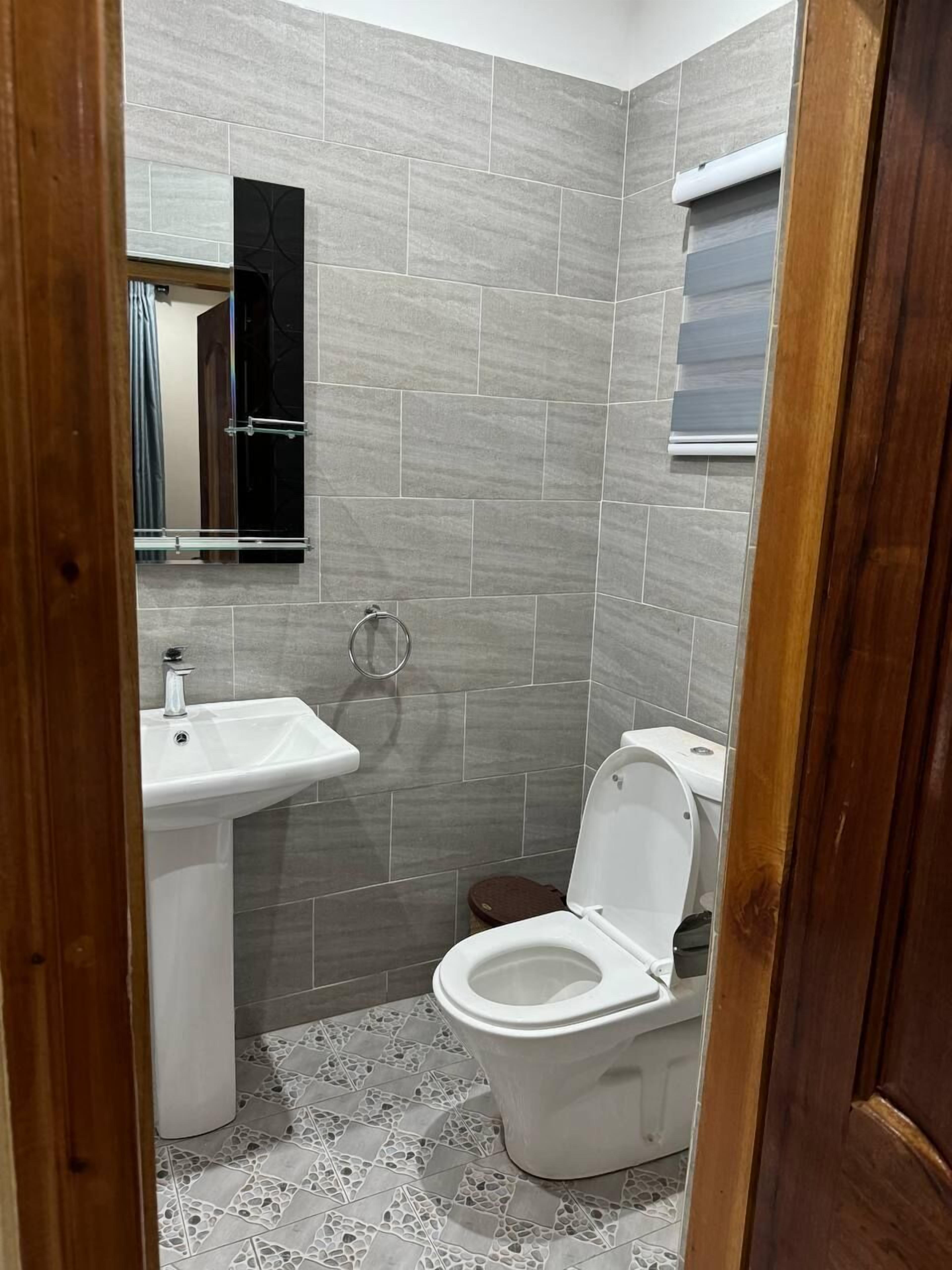 A bathroom with a sink, toilet, and mirror.