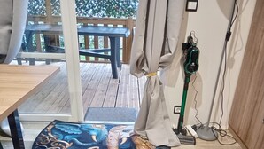 Ein Zimmer mit Holzboden, einem runden Teppich mit Drachenmuster, einem Tisch und einem Stuhl.
