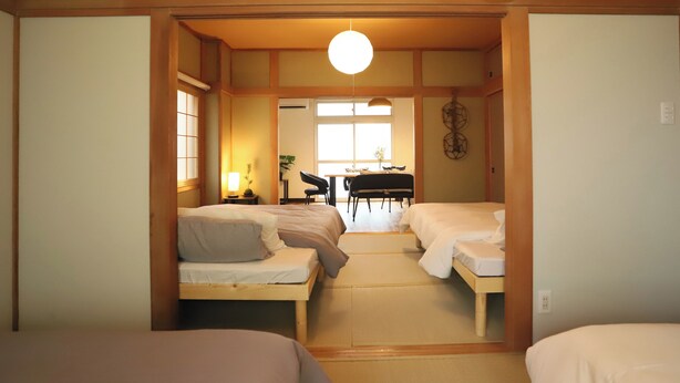 Una habitación con dos camas, una mesa de comedor y una silla.