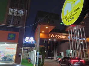 A JW Condo building with a 'Grab Sleep Hotel' sign, a pharmacy, and a gated entrance. - Grabsleep&Khokeng (Bangkok)