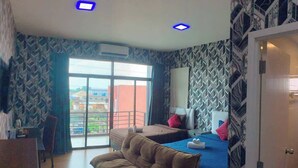 A hotel room with a bed, a sofa, a desk, and a view of the outside. - Grabsleep&Khokeng (Bangkok)