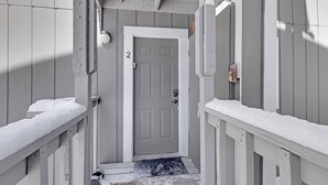 A narrow hallway with a gray door marked with the number 2, leading to a room. - Cozy two bedroom Breckenridge, steps away from Bus stop to mountain and downtown (Breckenridge)