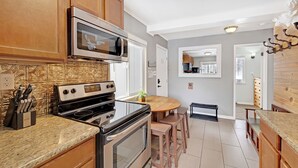 A kitchen with wooden cabinets, a stainless steel oven, a microwave, and a granite countertop. - Cozy two bedroom Breckenridge, steps away from Bus stop to mountain and downtown (Breckenridge)
