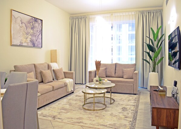 A living room with two sofas, a coffee table, a side table, and a large plant.