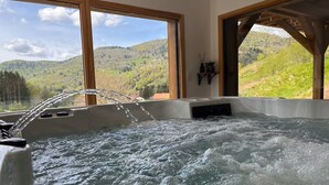 A hot tub with a view of green hills and a clear sky. - Chalet Alpage 10 persons (Bussang)