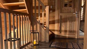 A wooden staircase with a handrail, a door with a window, and two lanterns on the floor. - Chalet Alpage 10 persons (Bussang)