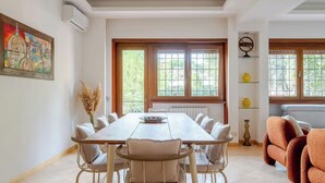 A dining area with a long table, chairs, and a window with a view of greenery. - Luxury apartment " Magdalene House " (Roma)