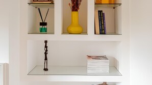 A white wall with three shelves, each containing various decorative items. - Luxury apartment " Magdalene House " (Roma)