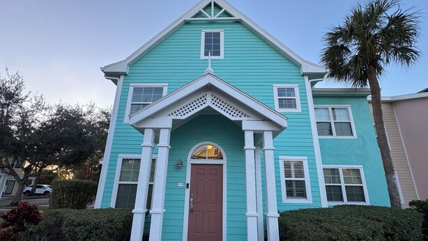 A two-story house with a front porch, a brown door, and a small window above the door. - ★Full Equipped Villa 8 guests 2Br/2Bth Pool and Free Shuttle to Disney Parks★ (Kissimmee)