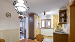 Una cocina con armarios de madera, una mesa de comedor y una lámpara colgante.