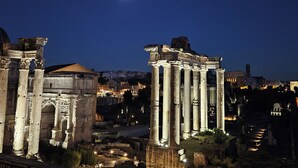 Des ruines antiques, avec des colonnes, et une lune dans le ciel.