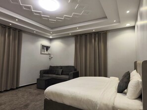 Una camera d'albergo moderna con un letto grande, un divano e un tavolino.