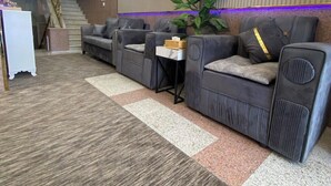 A modern lounge area with sofas, a small table, and a staircase. - Al Rayhan Suites (Madinah)