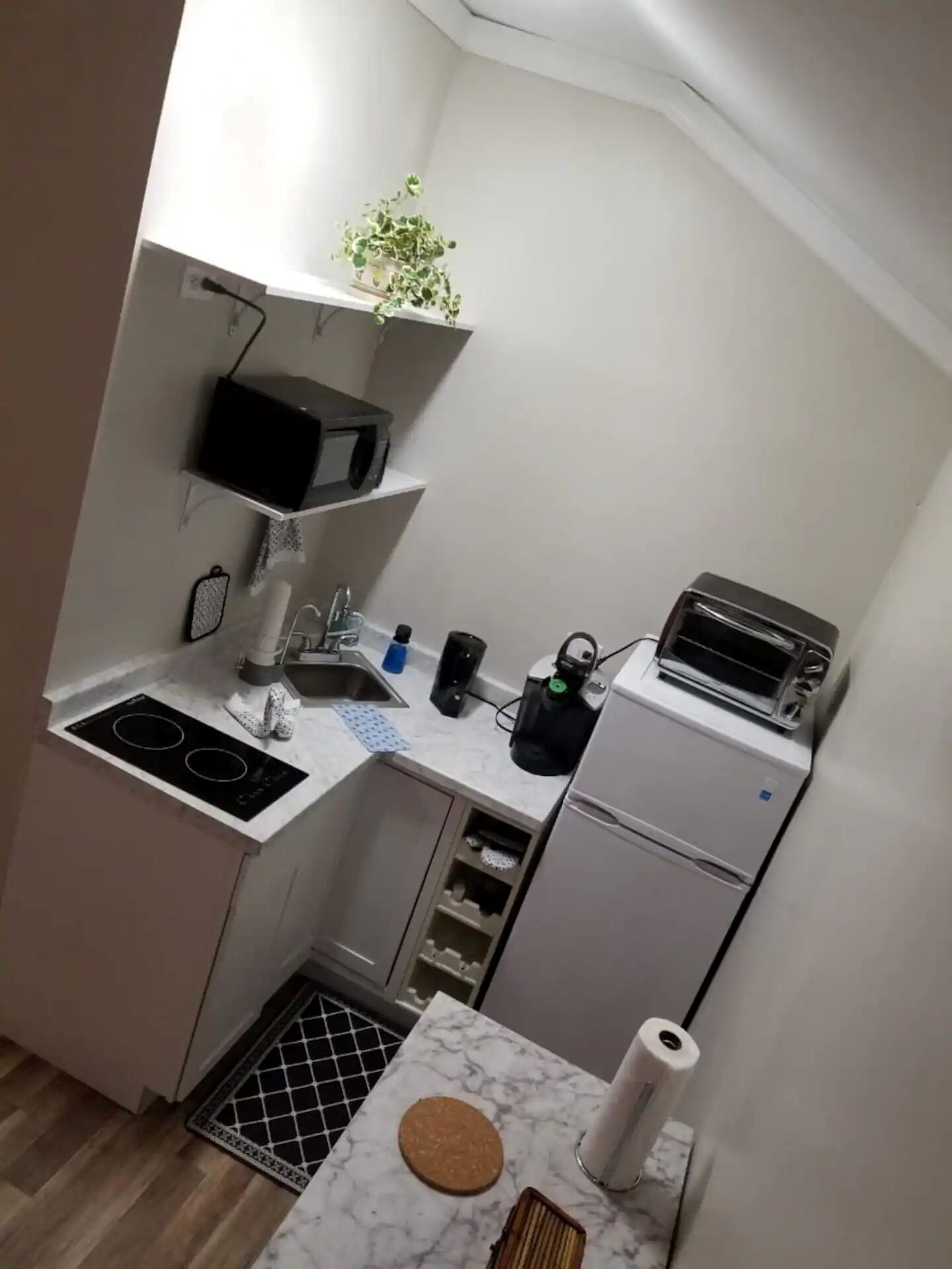 A compact kitchen with a stove, sink, and a small refrigerator.