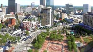 A cityscape with modern buildings, a Ferris wheel, and a parking lot. - Luxury Wyndham Margaritaville suite with short walk to football game fullKitchen (Atlanta)