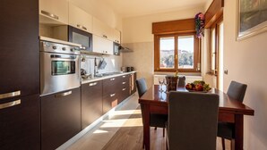 Une cuisine moderne dotée d’appareils électroménagers en acier inoxydable, de meubles en bois et d’un coin repas avec une table et des chaises.