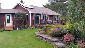 A two-story house with a well-maintained lawn and a variety of colorful flowers in the garden. - Spacious country retreat, close to Montpelier, close to nature. Smoke/pet free (Montpelier)